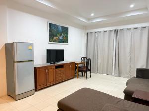 a living room with a refrigerator and a television at Serene Resort Pattaya in Nong Prue