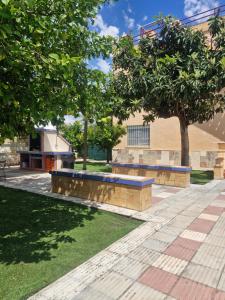 a park with two benches in front of a building at Apartamento ILA in Gandía
