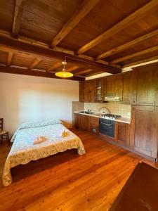 a bedroom with a bed and a kitchen with wooden floors at Hotel Panoramico in Corfino