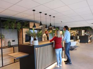 a group of people standing at a counter in a store at ibis Aubenas in Aubenas +84 photos