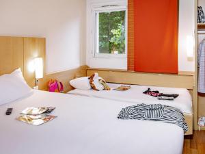a hotel room with two beds and a window at ibis Mulhouse Centre Filature in Mulhouse +40 photos