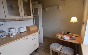 a small kitchen with a table and a small table with chairs at Light street in Ķekava +8 photos