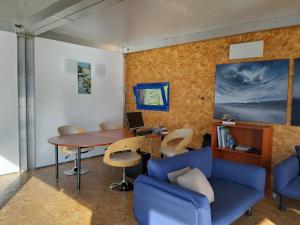an office with a blue couch and a desk and a table at Botel Diffuso dei Laghi in Porto Ceresio
