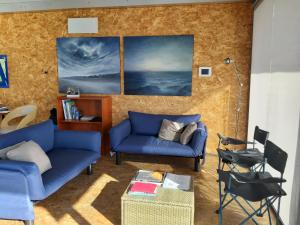 a living room with two blue couches at Botel Diffuso dei Laghi in Porto Ceresio