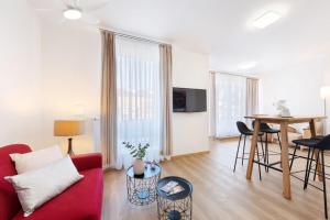 a living room with a red couch and a table at Prague Roof Apartments in Prague