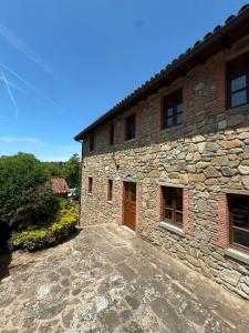 a stone building with a brown door on it at Hotel Panoramico in Corfino