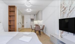 a bedroom with a bed with a television and a table at Ceglana Apart 01A in Katowice +3 photos