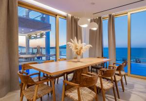 a dining room with a table and chairs and the ocean at Callisto Azzure in Zakynthos