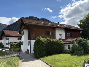 a house with a hedge in front of it at Ferienwohnung Vilstalstüble in Pfronten