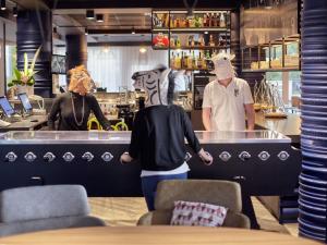 two people dressed in animal masks standing at a bar at Hotel Mercure Château de Fontainebleau in Fontainebleau