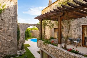 an external view of a stone house with a patio and an archway at Villa Bilja Historic Stone Castle in Trebinje