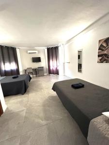 a hotel room with two beds and a television at Hotel Velis in Vélez-Málaga