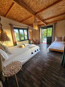 a bedroom with a large bed in a room with windows at Meezane Farmhouse in Bir Jedíd Saint-Hubert