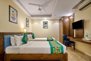 a hotel room with a bed and a desk at Treebo Premium PL Grand, Visakhapatnam in Visakhapatnam