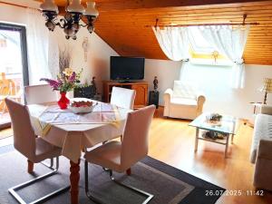 a living room with a table and chairs and a television at Fischer Willi in Bad Koetzting