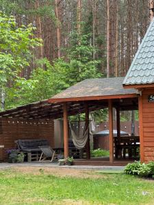 a gazebo with a hammock and a bench at Chata przy lesie - sauna i balia in Łuka