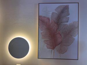 a picture of a large leaf on a wall with a mirror at Mersea standard apartment Kourouta in Kourouta