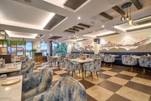 a restaurant with tables and chairs and a checkered floor at Treebo Premium PL Grand, Visakhapatnam in Visakhapatnam