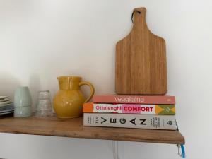 a stack of books on a shelf with a vase at Le Son des Violons in Sallèles-dʼAude