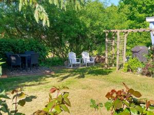 a yard with chairs and an arch and a table at Bungalow Koje in Kröslin