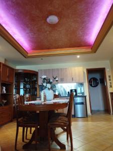 a kitchen with a table and a purple ceiling at Marilyn's house in Amarynthos +9 photos