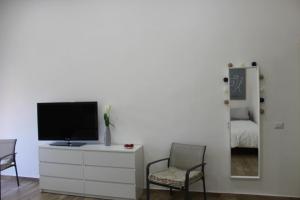 a living room with a tv on a dresser and two chairs at Carpenters Guest House in Pompei