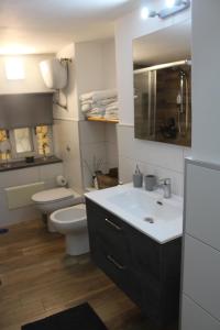 a bathroom with a sink and a toilet and a mirror at Carpenters Guest House in Pompei