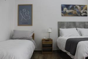 a bedroom with two beds and a table with a lamp at Carpenters Guest House in Pompei
