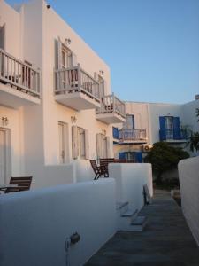 un grupo de edificios blancos con mesas y sillas en Mykonos Chora Residences, en Mykonos ciudad
