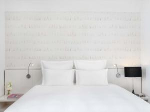 a bedroom with a white bed with white pillows at Nemzeti Hotel Budapest - MGallery Collection in Budapest
