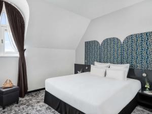 a bedroom with a large white bed and a window at Nemzeti Hotel Budapest - MGallery Collection in Budapest