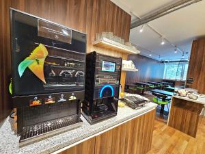 ein Zimmer mit Küche und großem Fernseher in der Unterkunft Atelier Hotel in Ljubljana