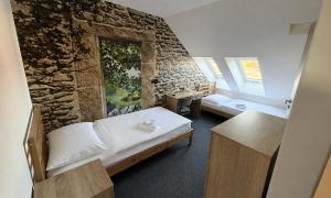 a room with a bed and a stone wall at Aroma Gold in Dolní Bousov