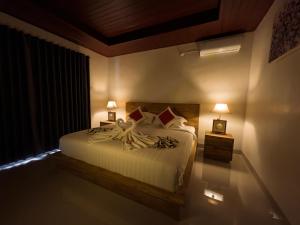 a bedroom with a large bed with two lamps on it at JERO Tabola 2 in Sidemen
