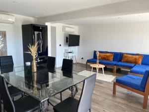 a living room with a glass table and blue couch at Appartements Mistral in Pyla-sur-Mer
