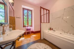 a bathroom with a tub and a sink at La maison des jours heureux in Leysse +50 photos