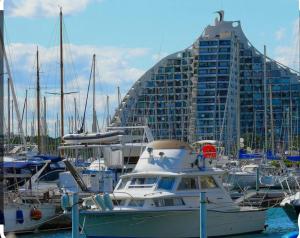 a group of boats docked in a harbor with a large building at 100m de la plage in La Grande Motte +1 photo