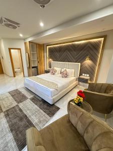 ein Schlafzimmer mit einem großen Bett und einer Couch in der Unterkunft Hotel Naim Wakeel in Islamabad