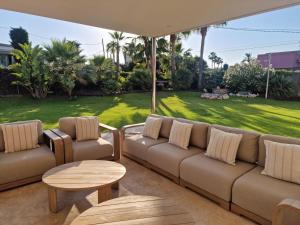 a couch and chairs on a patio with a lawn at Luxury Beach House in Sitges
