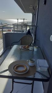 a table with a plate of food and two cups on it at Aleksandra Delfini Apartments in Paralia Katerinis