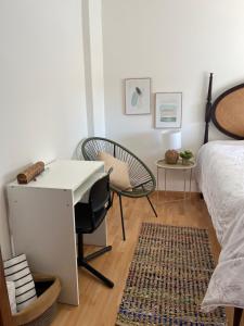a bedroom with a desk and a bed and a chair at Mar de rosas in Carcavelos