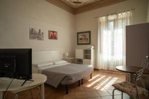 a bedroom with a bed and a tv in a room at Casa di Alfredo Affittacamere in Siena