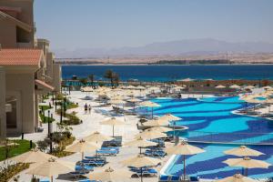 an overhead view of a pool with umbrellas and the ocean at SRNTY Sahl Hasheesh - Ex Serenity Sky Arc in Hurghada