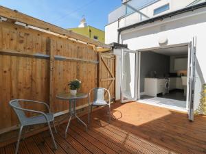 a patio with a table and chairs on a wooden deck at 38 The Parade in Walton-on-the-Naze