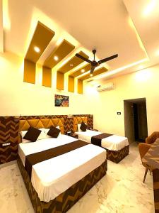 a bedroom with two beds and a ceiling fan at Premium Hotel EXO-Near Temple and Ghat#Parking and Comfort Stay#Premium Service in Varanasi +13 photos