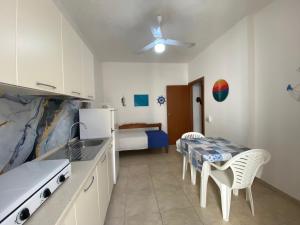 a kitchen with a table and chairs and a bedroom at Vento a poppa in Porto Palo
