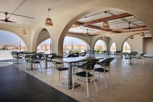 a row of tables and chairs in a room with arches at SRNTY Sahl Hasheesh - Ex Serenity Sky Arc in Hurghada