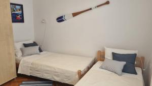 a room with two beds and a baseball bat on the wall at Apartment Sanjug in Šilo