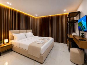 a bedroom with a bed and a desk and a television at Dine Hotel in Ksamil