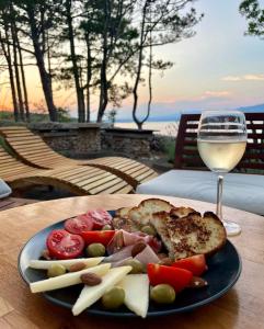a plate of food on a table with a glass of wine at Apartment Sanjug in Šilo